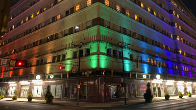 An apartment building in downtown with LED outdoor lighting show in multiple colors