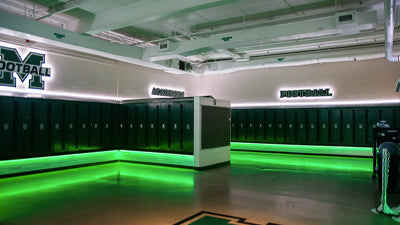 A locker room with color LED lighting displayed in green and white